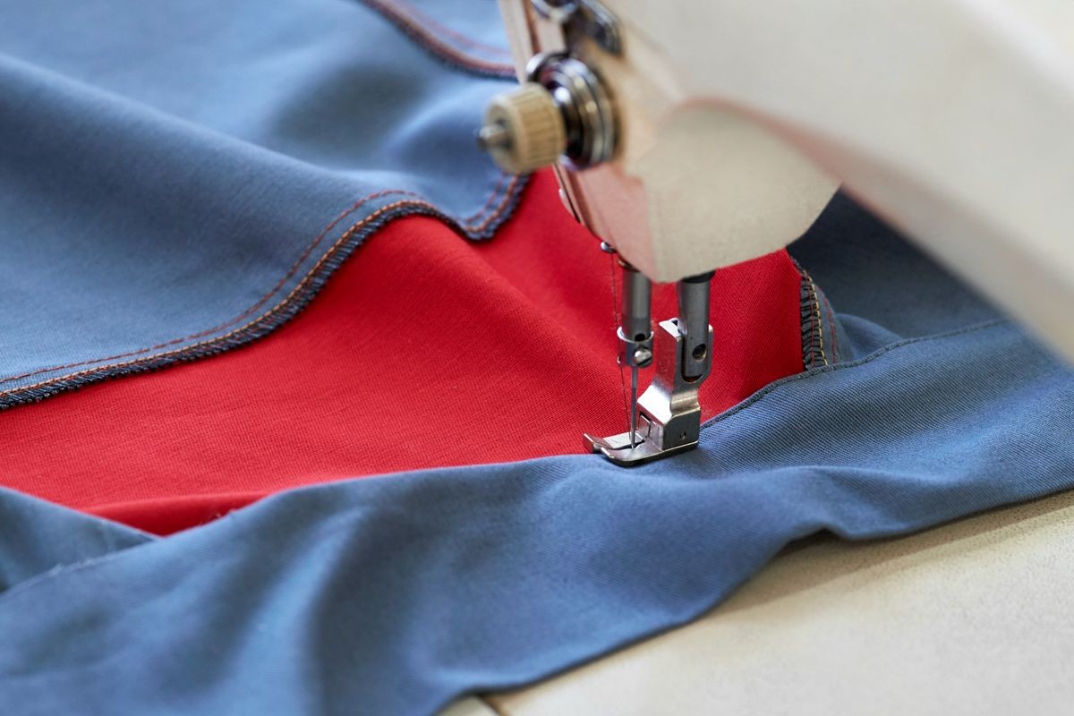 Closeup of the process of sewing a fabric on a mechanical machine in the workshop of a sewing workshop for sewing protective clothing for special purposes.